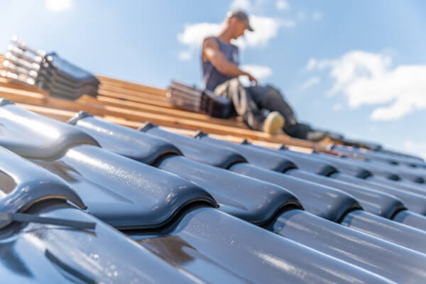 Roofer fitting slates on a Victorian Leicester terrace